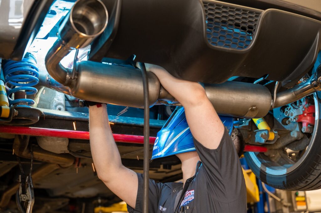 custom exhaust system being installed on a vehicle in Garys